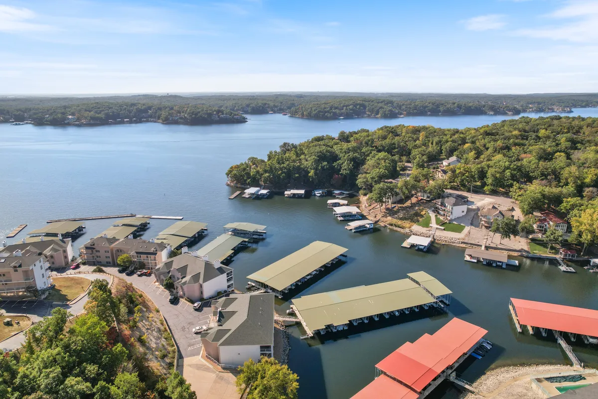 A wide view of the lake showing marinas, surrounding greenery, and homes dotting the shoreline. The image captures boating and fishing activities as well as the vibrant yet tranquil community atmosphere along the water.