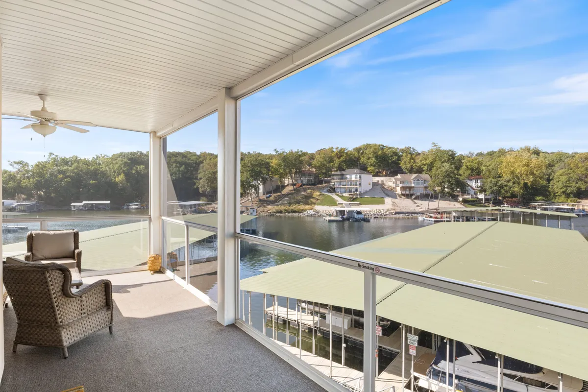 A comfortable chair is positioned with a clear view over the water and marina, inviting relaxation while watching boats, fishing, or enjoying the peaceful lake atmosphere. The setting is tranquil and highlights community and leisure on the water's edge.