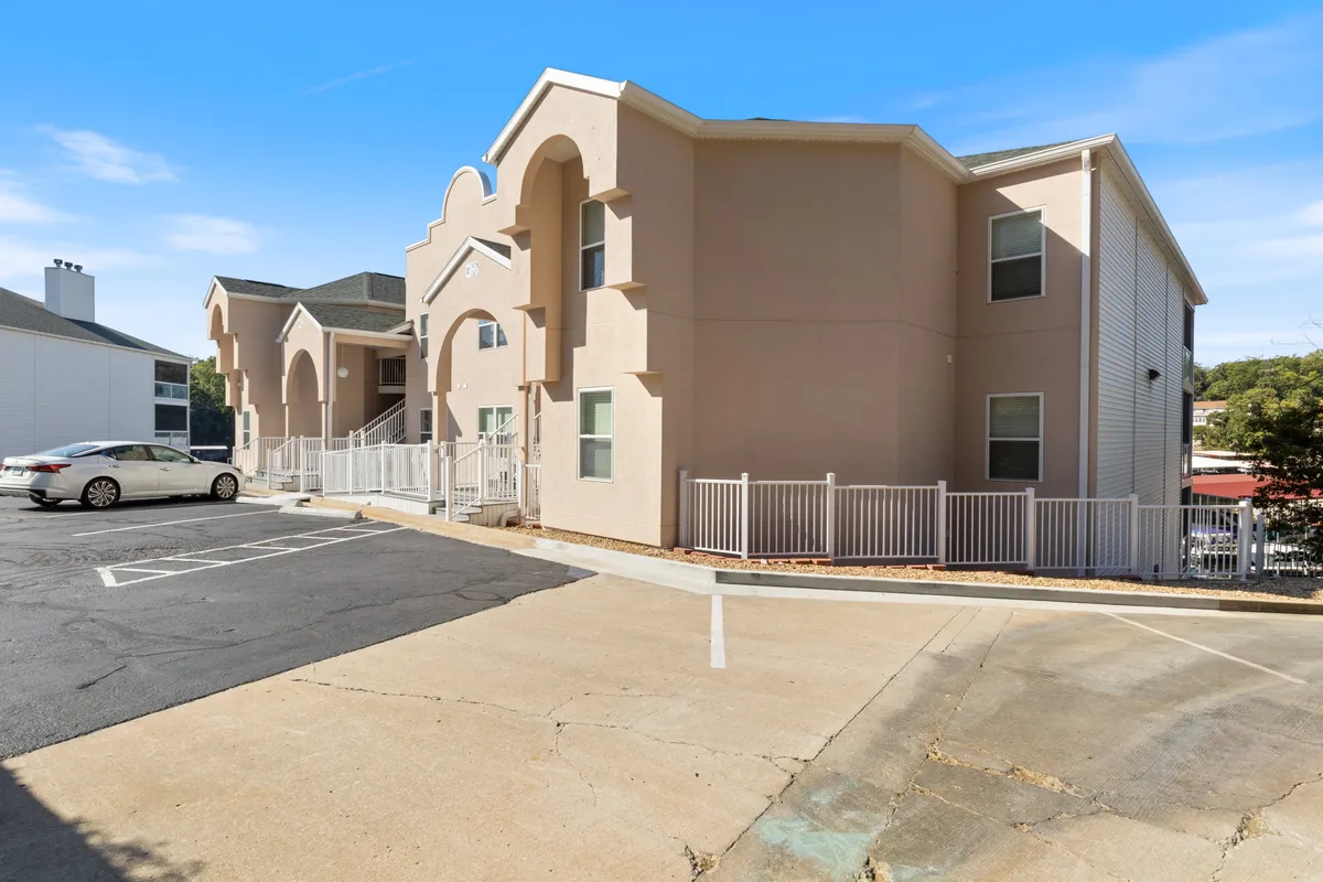 This exterior shot features the building’s architectural details, parking area, and surrounding greenery. It captures the essence of a friendly residential community, showing how guests can easily access the property from the parking lot, and how the neighborhood is safe and inviting.